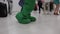 Animator in green costume dances with children loud fast music from speaker
