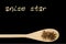 Anise star on wooden spoon isolated on black background. Latin name Illicium verum