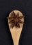 Aniseed star in a wooden spoon. Traditional cooking. Vertical