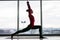 Anjaneyasana. Beautiful yoga woman practice crescent lunge poses in a big window