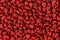 Annatto seeds, achiote seeds, bixa orellana background. Natural dye for cooking and food. Close-up.