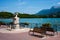 Annecy lake riverbank with bench and sundial and Veyrier mount o