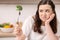 Annoyed bleak woman eating broccoli