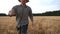 Annoyed farmer running to camera through the wheat field and trying to catch somebody. Angry agronomist jogging among