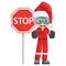 Annoyed industrial mechanic worker with Santa Claus hat stop sign. Engineer with his personal protective equipment. Merry