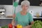 Annoyed senior woman ready to catch an insect inside of her house