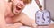 Annoying ringing alarm clock. Man bearded annoyed sleepy face lay pillow near alarm clock. Guy knocking with hammer