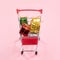 Annual sale, Christmas shopping season concept - mini red shop cart trolley full of gift box isolated on pale pink background,