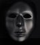 Anonymous black mask protruding from pitch black background.