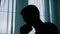 Anonymous blurred silhouette of a man talking on a cell phone, a criminal is extorting money