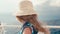 Anonymous elderly blonde woman with long hair and straw hat sitting on upper deck of ferry ship motorboat enjoying