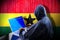 Anonymous hooded hacker, flag of Ghana, binary code - cyber attack concept
