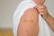 Anonymous lady showing the plaster covering her vaccination site