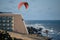 Anonymous man paraglides at the beach.