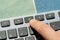 Anonymous man pressing the mute button, sound off key on a modern computer keyboard, hand, finger closeup, detail. Muting