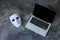 Anonymous mask to hide identity on computer laptop - internet criminal and cyber security threat concept