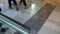 Anonymous people walking in shopping centre, detail on feet and marble floor