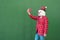 Anonymous person dressed in christmas clothes taking a selfe with a red mobile