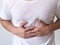 Anonymous person pushing his belly with hands due to stomach cramp pain or chronic gastritis illness