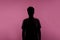 Anonymous person. Silhouette portrait of young man in casual T-shirt isolated on pink background