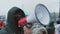 Anonymous Russian protester gives address with loudspeaker megaphone. City riot.