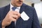 Anonymous salesman placing white card in pocket