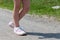 Anonymous unrecognizable elementary school age child walking down the road wearing generic velcro sport shoes legs closeup, one