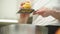 Anonymous woman grating lemon zest over metal bowl in kitchen