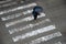 Anonymous woman with umbrella crossing street