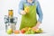 Anonymous woman wearing an apron, offering glass of freshly pressed juice, healthy lifestyle concept