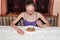 Anorexia. Skinny anorexic girl holding a spoon and look at the plate with food