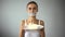 Anorexic girl holding pie, fasting word written on taped mouth, ban on sweets