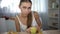 Anorexic girl measuring apple with tape, counting calories and body mass index