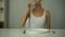 Anorexic girl sitting in front of empty plate, drinking water, severe diet