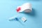 Anoscope, suppositories and toilet paper with red feather on light blue background. Hemorrhoid treatment