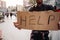 Another picture of cardboard which says help. It is hold by a jobless man. He is also a homeless man. He is looking for