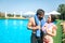 Another picture of well-built and slim couple standing together at the edge of swimming pool. They look at each other