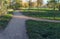 Another trail joins a wide winding alley in the park. Autumn conceptual landscape