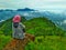 Another woman sits on a rock at the top of a hill called Bukit Besar, located in Lahat, South Sumatra Province, Indonesia