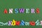 ANSWERS word on green background composed from colorful abc alphabet block wooden letters, copy space for ad text