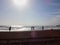 Antalya, Turkey - December 26, 2019: View from sand beach to water of sea, waves, pier and black silhouette of person in a nice