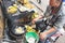 Antananarivo, Madagascar - April 24, 2019: Local Malagasy woman frying bananas in oil at her stall on market next to main road.