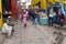 Antananarivo, Madagascar - April 24, 2019: Two unknown young Malagasy girls walking cobblestone road, more people around at their