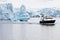 Antarctic iceberg, beautiful shaped iceberg with research ship in front