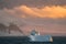 Antarctic Iceberg nature landscape during midnight sun sunset sunrise in the horizon. Early morning summer alpenglow