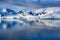 Antarctic landscape with snow-capped mountains reflecting in dark blue water of Lemaire Channel near Paradise Bay, Antarctica