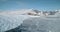 Antarctica glacier ocean shore landscape aerial. Melting snow covered glacier at winter sun day.