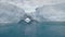 Antarctica icebergs with arch reflected in ocean.