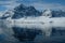 Antarctica orange kayak in a mirror blue bay beneath snow capped mountains