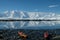 Antarctica orange and red kayaks in a mirror blue bay